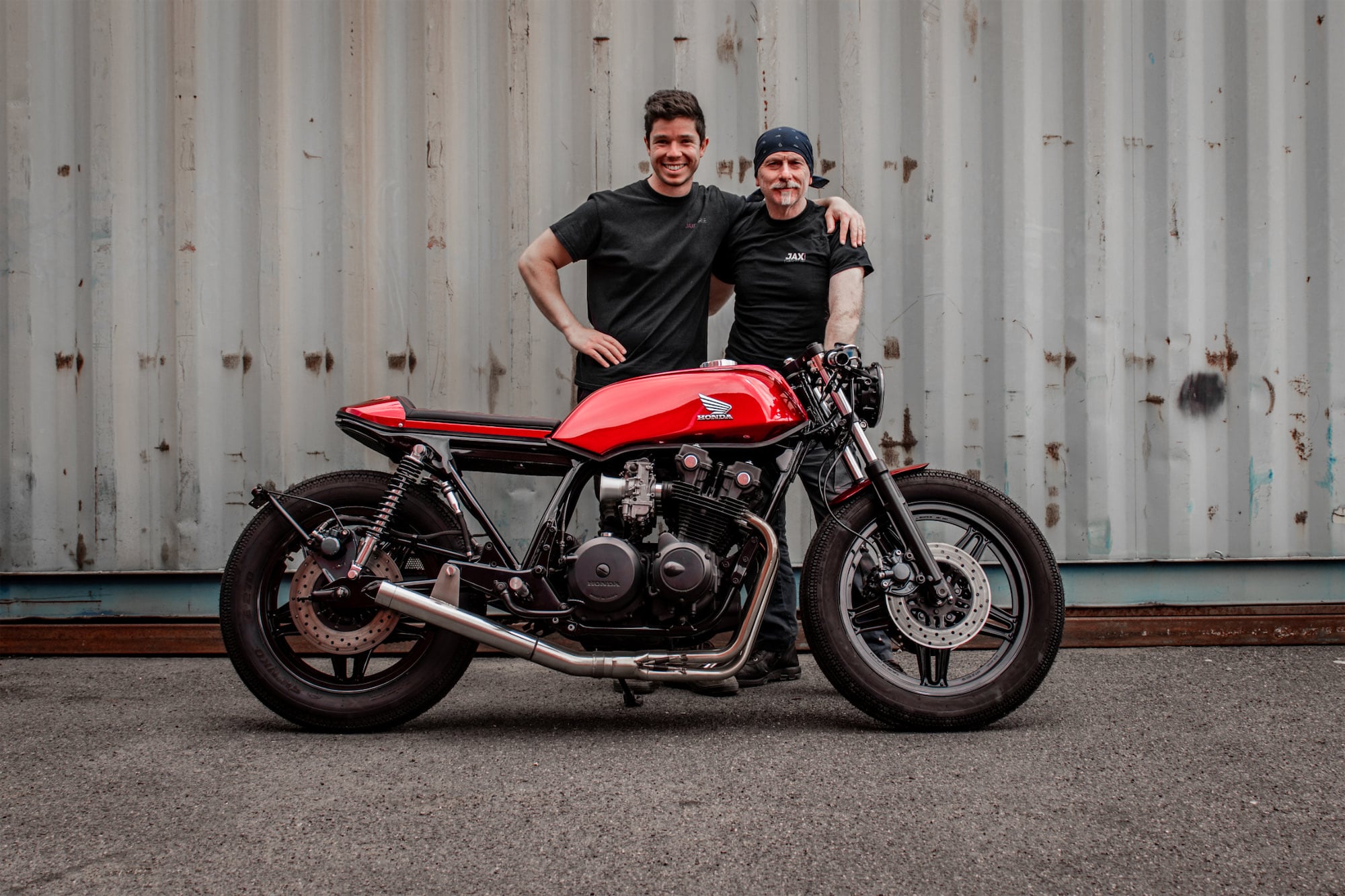 The Jax Garage team beside a red Honda CB750 F café racer they built, outside the Melbourne workshop
